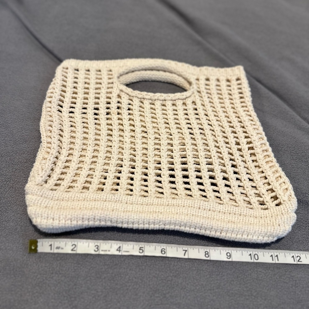 handmade cream-colored, open-knit crochet tote bag with built-in handles.